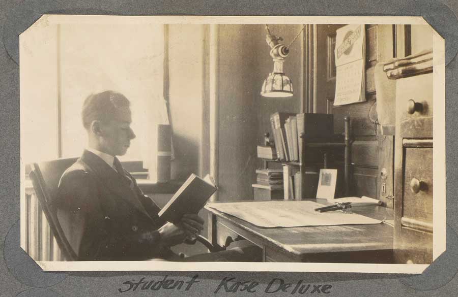 Old photo of Gettysburg student sitting at their desk with an electric light