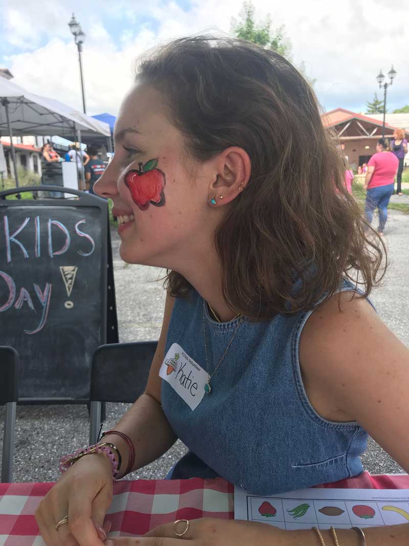 Katie Mercer with an apple painted on her face