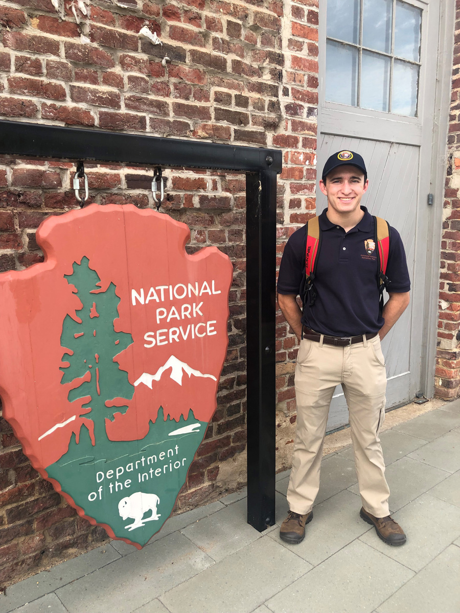 Sean Thompson standing next to a National Park Service sign