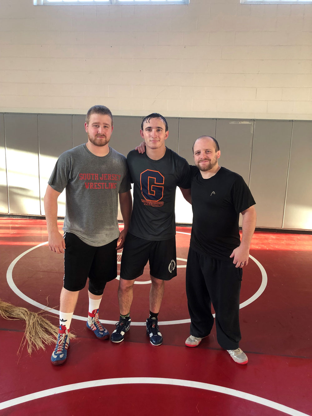 Sean Thompson posing with two other wrestlers in a gym